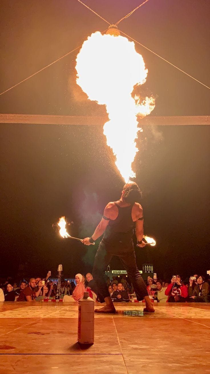 Fire performer at a Dubai desert safari camp at night