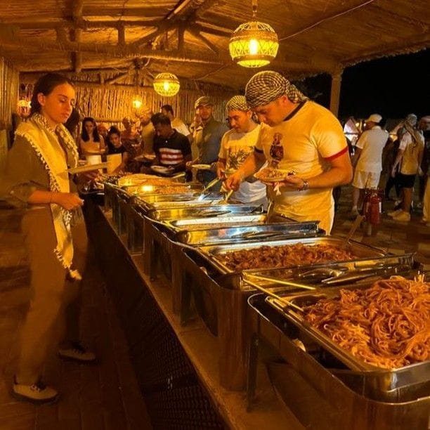 Guests being served from a buffet at a desert safari camp