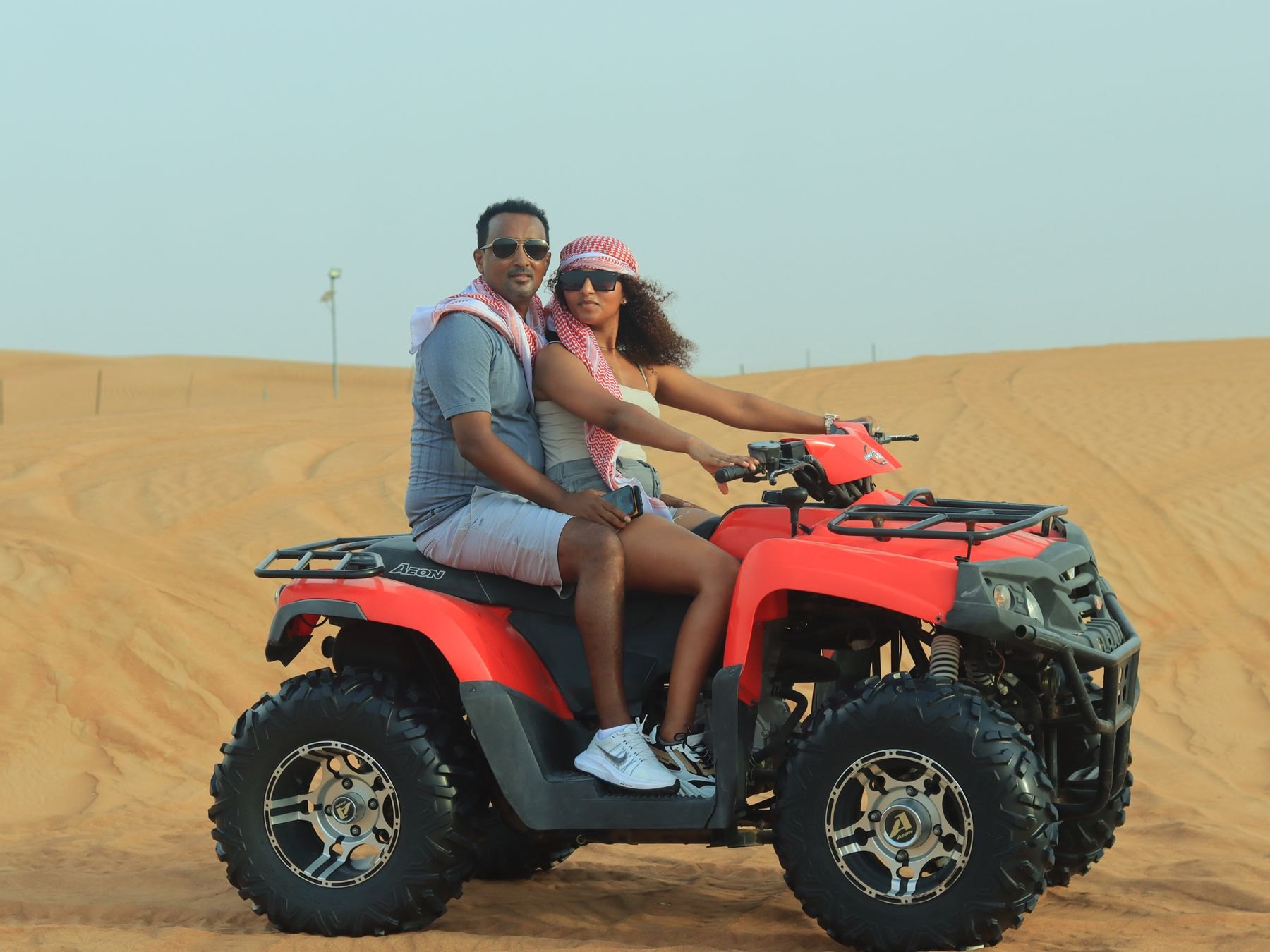 Couple seated on an ATV in the Dubai desert